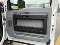 The interior door panel of a 2015 Ford F-350 SD featuring a gray and black design with a handle and storage compartment