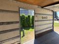 A 2022 Isuzu NQR truck with an open rear door showcasing the interior space with metal strips along the walls
