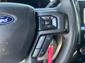 Steering wheel controls of a 2022 Ford F-350 SD featuring buttons for volume and phone functions