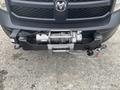 A 2016 RAM 1500 front bumper with a mounted winch featuring a metal cable and controls attached