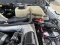 Close-up of a 2014 Ford F-250 SD engine compartment showing coolant reservoir hoses and electrical connections