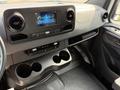 Interior view of a 2023 Mercedes-Benz Sprinter featuring a modern dashboard with a touchscreen display and multiple cup holders