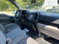 Interior of a 2019 Ford F-150 featuring grey fabric seats a dashboard with a touchscreen display and control buttons