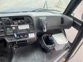 Interior view of a 2007 Freightliner B2 with dashboard controls cup holder and trash bin