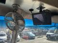 A 2012 Ford E-450 interior featuring a small metal fan mounted to the ceiling and a screen displaying a camera feed