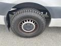 A close-up of a rugged tire mounted on a 2024 Mercedes-Benz Sprinter with a distinct tread pattern and a black steel wheel
