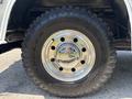 Close-up of a shiny chrome wheel on a 1995 Ford F-250 with a rugged Goodyear Wrangler Duratrac tire