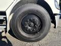 Close-up of a black wheel on a 2006 Freightliner M2 106 showcasing the rim and tire tread design
