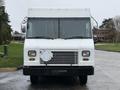 A white 2012 Ford Econoline delivery truck with a flat front and a rectangular grill featuring a missing license plate holder