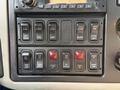 Control panel of a 2011 International 7500 featuring various switches and buttons for functions like dump, tarp, and gate operations