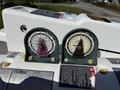 Two circular gauges displaying pressure readings with one gauge in purple and the other in beige mounted on a white control panel