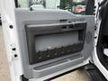 A gray door panel of a 2015 Ford F-350 SD featuring a handle and a large storage compartment