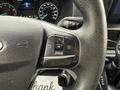 The steering wheel of a 2022 Ford Transit with buttons for navigation and controls visible