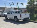 A white 2011 Chevrolet Colorado pickup truck parked on the street with a gray bumper and alloy wheels
