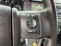 Close-up of a 2019 Ford F-750 steering wheel showing audio control buttons including seek media and volume