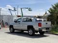 A 2016 Chevrolet Silverado 2500HD pickup truck in silver parked with its bed visible and a chrome bumper