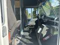 Interior of a 2012 Ford E-450 showing driver seat steering wheel and dashboard with various controls and a fire extinguisher mounted to the side