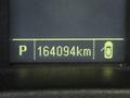 A digital display showing the gear position as "P" and the mileage as 164094 km on a vehicle dashboard