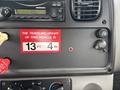 A dashboard featuring a radio, instrument cluster, a height restriction sign stating the vehicle's height, a power outlet, and various controls