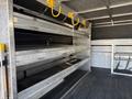 A 2019 Ford F-150 with an open truck bed featuring multiple metal shelves and yellow hooks for organizing tools and equipment