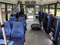 Interior view of a 2020 Chevrolet Express showing blue seats arranged in rows with a spare tire secured in the middle aisle.