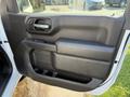 Interior door panel of a 2022 GMC Sierra 1500 featuring a black handle and a large armrest with a storage compartment