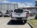 A white 2020 Ford F-350 Super Duty truck is parked facing backward with a chrome rear bumper and dual exhaust pipes visible