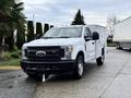 A white 2017 Ford F-350 SD with a utility bed standing in a driveway