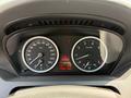 Dashboard of a 2004 BMW 6-Series featuring speedometer and tachometer with a digital display in the center showing trip distance and fuel warning light