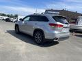 A silver 2018 Toyota Highlander parked with its rear facing the viewer showcasing its sleek design and alloy wheels