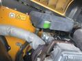 A 2013 JCB 510-56 Loadall engine compartment showing various components including a grey-covered hose and a green fluid reservoir