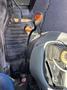 A close-up of a 2010 New Holland T4050 tractor's gearshift and controls showcasing the levers and foot pedals