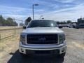 Front view of a 2014 Ford F-150 with a silver exterior black grille and headlights