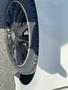 A close-up of a black alloy wheel of a 2014 Mercedes-Benz CLA-Class with a low-profile tire showing some wear on the tread
