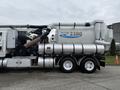 A 2013 International Workstar 7500 truck equipped with a Vactor 2100 vacuum system featuring large tanks and hoses for industrial cleaning purposes