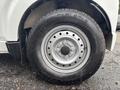 Close-up of a wheel of a 2008 Suzuki Carry featuring a silver rim and a black tire with tread patterns and branding visible