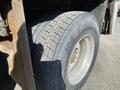 Close-up of a large tire mounted on a 2014 International 7400 truck with visible tread patterns and a partially rusted rim