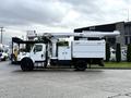 A 2015 Freightliner M2 bucket truck with a white body and elevated boom arm for utility work