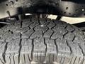 Close-up of a rugged tire tread from a 2013 Ford F-250 SD showcasing deep grooves and a strong grip pattern designed for off-road traction