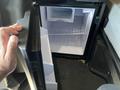 A person holds the door of a small refrigerator inside a 2022 Freightliner Cascadia with an empty interior and a pull-out shelf