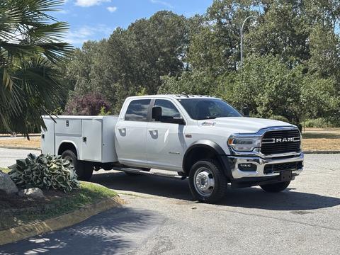 A 2021 RAM 5500 truck in white with a utility bed showcasing chrome accents and a distinctive front grille