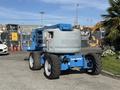 A 2012 Genie Z 45/25 boom lift with large tires and a gray platform mounted on a blue frame facing right