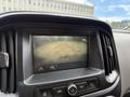 A display screen showing the rearview camera feed of a 2017 Chevrolet Colorado with red guidelines for parking assistance
