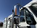 A close-up of a shiny chrome exhaust stack and side mirror on a 2008 International 7500 truck with an amber clearance light