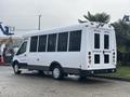 A white 2021 Ford Transit-350 with large windows and a wheelchair lift at the rear
