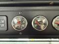 Dashboard of a 2010 Autocar Xpeditor featuring three gauges for engine oil temperature transmission oil temperature and a warning light