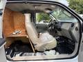 Interior of a 2008 Ford F-450 SD featuring two front seats and a wooden panel behind them with hooks attached