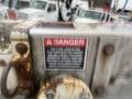 A close-up of a warning label on a metal platform with a red and black danger sign indicating weight limits and safety hazards