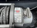 A Warn M8000-S winch mounted on a 2017 Chevrolet Colorado with a steel cable and control lever visible