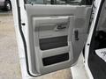 A close-up view of the driver's side door panel of a 2017 Ford E450 showing the handle and armrest in a gray interior design
